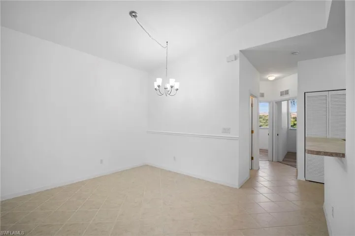 Unfurnished room with hanging lights and light tile patterned flooring