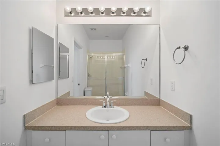 Full bathroom with vanity and a shower stall