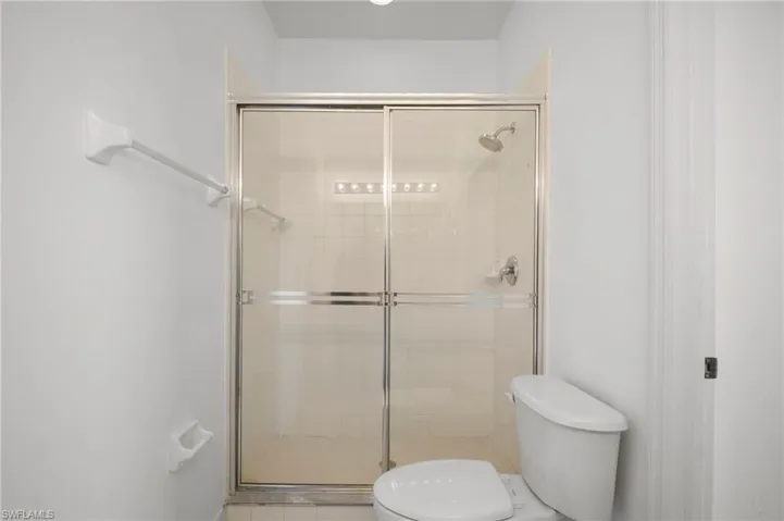 Bathroom featuring toilet and a stall shower