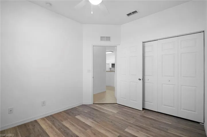 Unfurnished bedroom featuring wood finished floors, a ceiling fan, and a closet