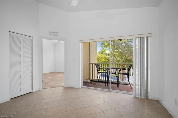 Empty room featuring a high ceiling, light tile patterned flooring, and ceiling fan