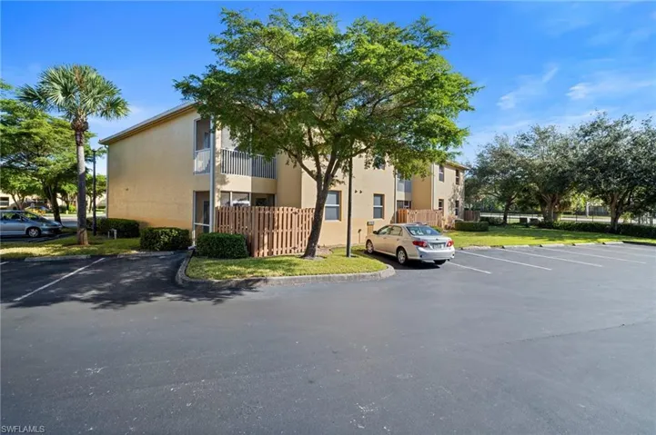 View of apartment building / complex featuring uncovered parking