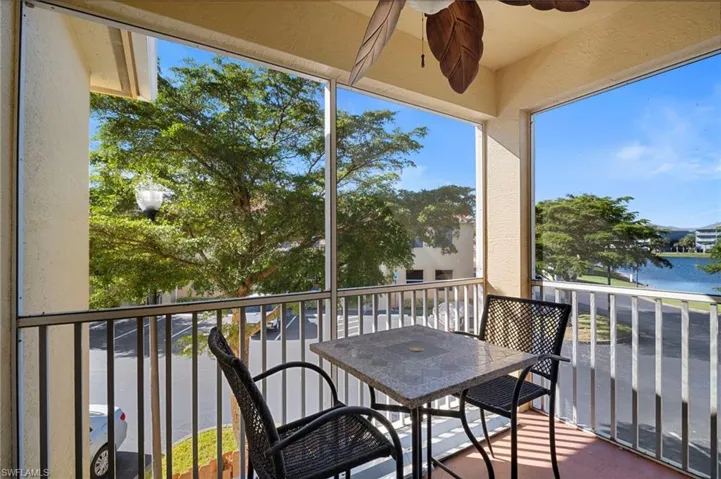 Balcony featuring a ceiling fan and a water view