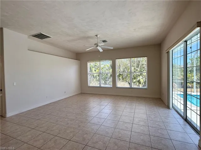Living room plenty of natural light looking out to pool.