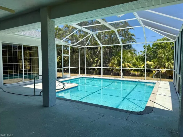Outdoor pool with screen enclosure and a patio area