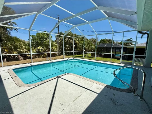 Pool with a patio and screen enclosure.