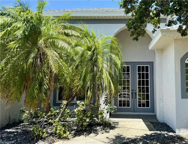 Doorway to property with French doors and stucco siding.