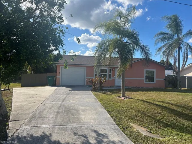 Ranch-style home with driveway, an attached garage, and stucco siding