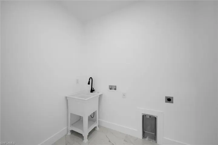 Clothes washing area with tile floors, hookup for a washing machine, and hookup for an electric dryer