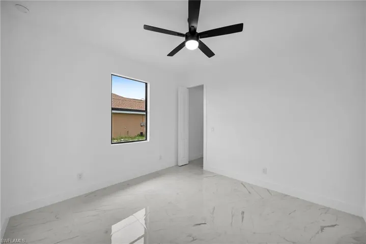 Tiled empty room with ceiling fan
