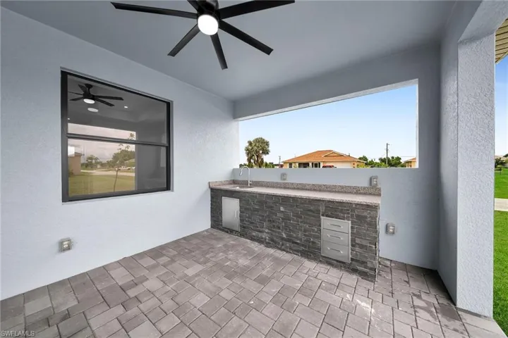 View of patio / terrace featuring ceiling fan, an outdoor kitchen, and sink