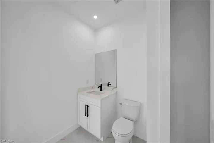Bathroom with vanity, toilet, and tile floors