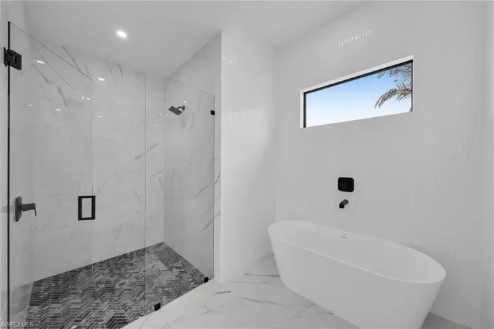Bathroom featuring tile floors and separate shower and tub