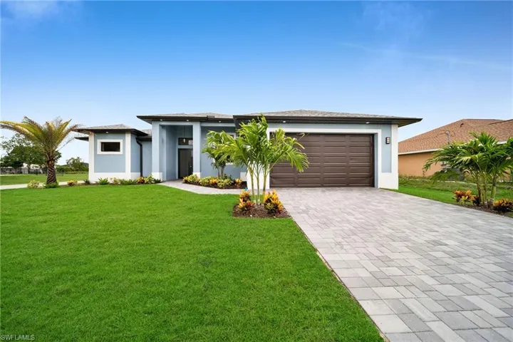 View of front of house featuring a front yard and a garage