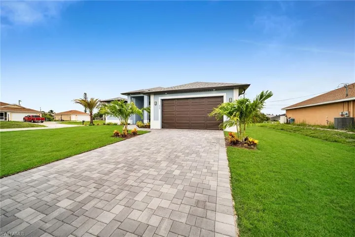 Ranch-style house with a garage, a front yard, and central AC unit