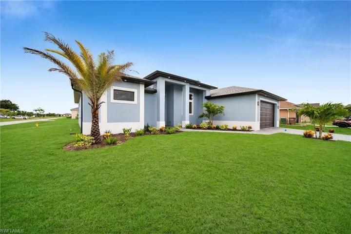 View of front of home with a garage and a front lawn