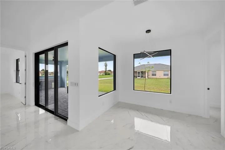 Empty room with a notable chandelier and light tile flooring