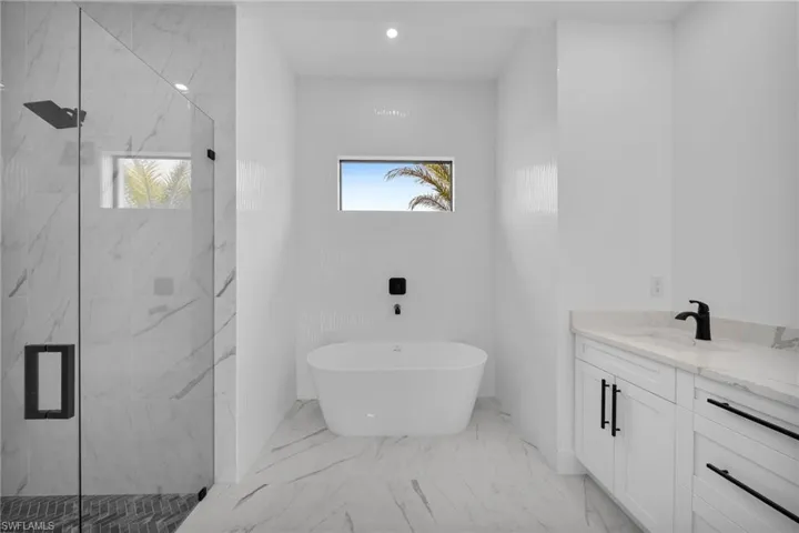 Bathroom featuring tile flooring, vanity, and independent shower and bath