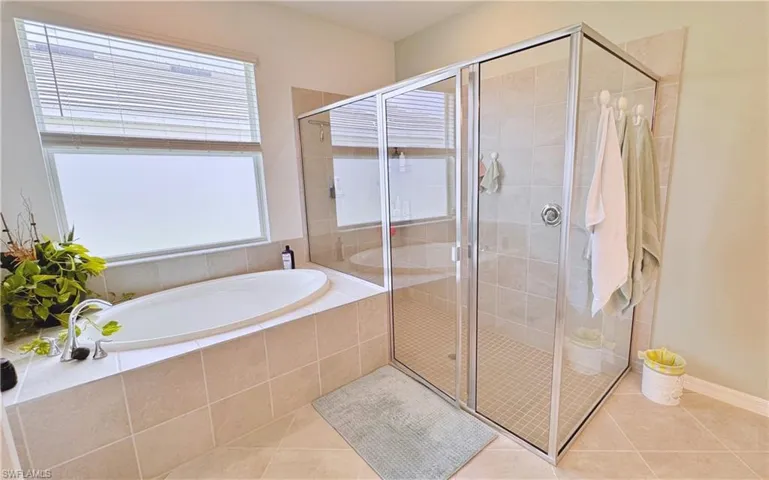 Bathroom with tile patterned flooring and independent shower and bath
