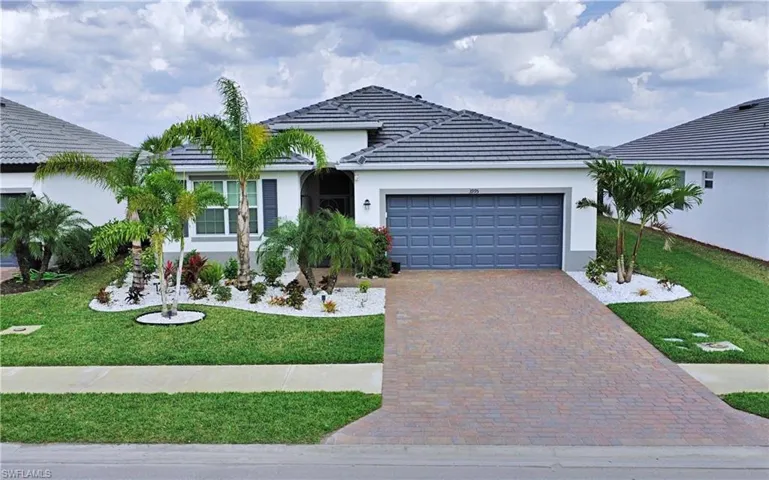 Ranch-style home featuring a garage and a front lawn