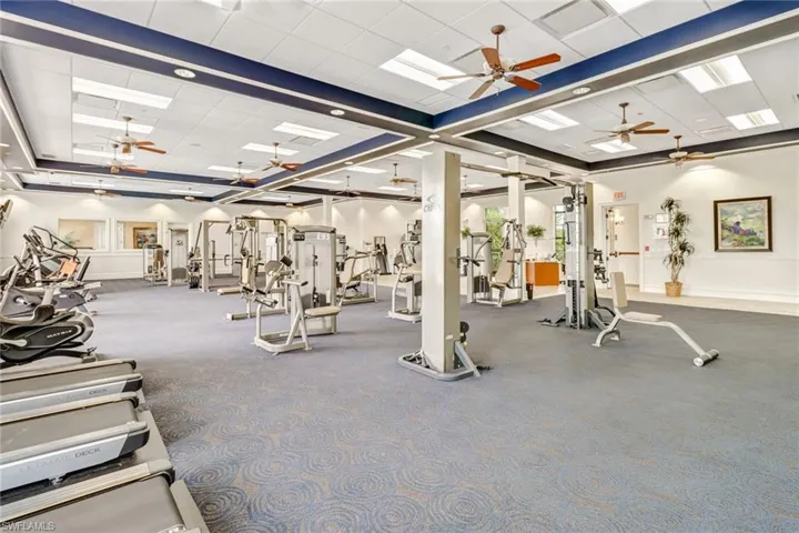 Gym with baseboards and ceiling fan