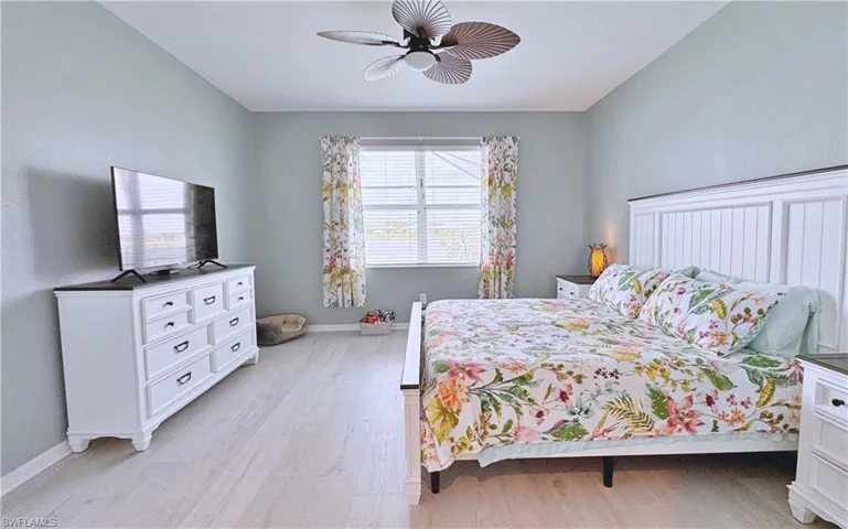 Bedroom with ceiling fan and light wood-type flooring