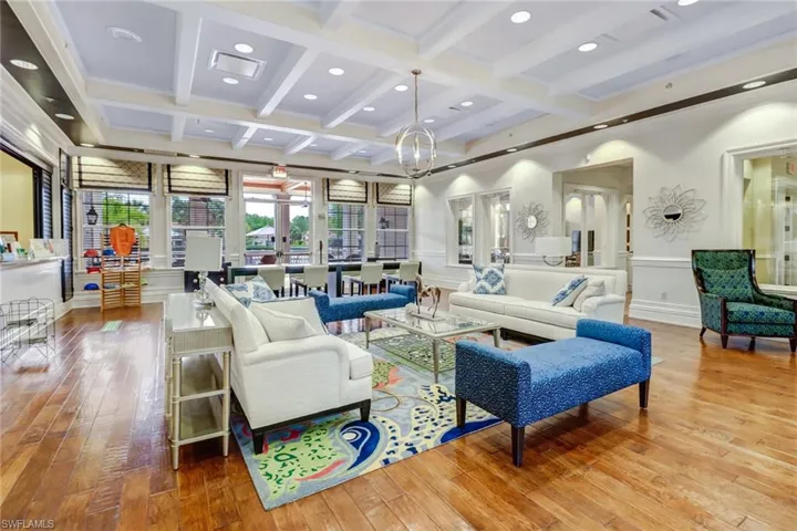 Living room with hardwood / wood-style flooring, beam ceiling, recessed lighting, a wainscoted wall, and coffered ceiling