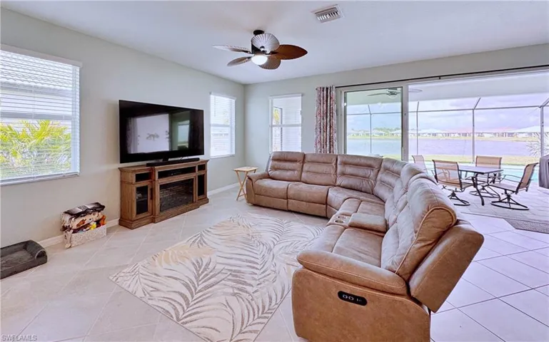 Living room featuring ceiling fan, a healthy amount of sunlight, and light tile patterned floors