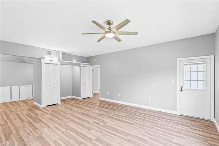 Unfurnished bedroom featuring light wood-style flooring, a ceiling fan, and two closets