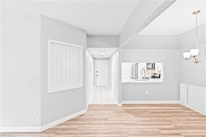 Unfurnished dining area with light wood-style flooring and a chandelier