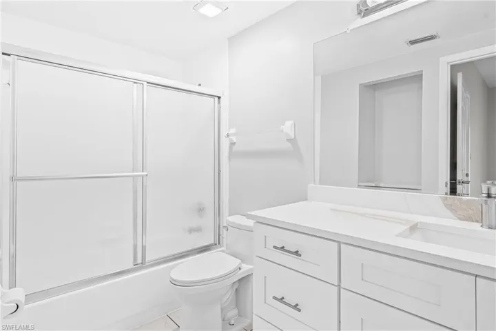 Full bath with vanity and bath / shower combo with glass door