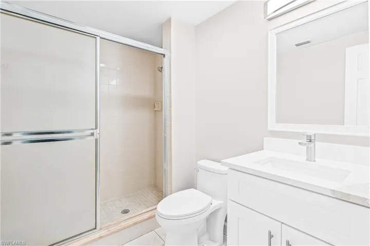 Full bathroom with vanity and a shower stall