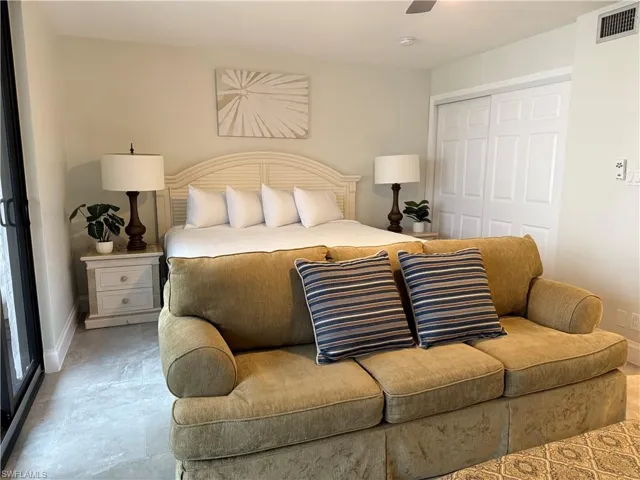 Bedroom with a closet, ceiling fan, and tile floors