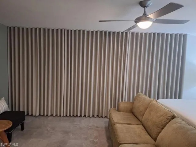 Sitting room featuring a ceiling fan and finished concrete flooring