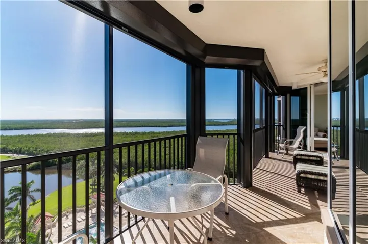 Sunroom / solarium with ceiling fan and a water view