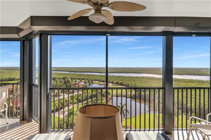 Unfurnished sunroom with ceiling fan and a water view