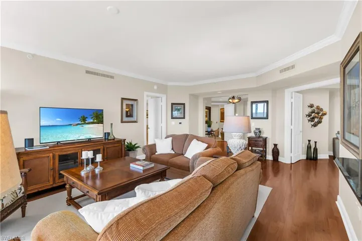 Living room featuring dark wood-type flooring and ornamental molding