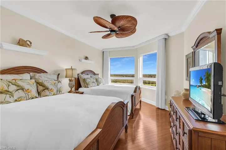 Bedroom featuring dark hardwood / wood-style floors, ceiling fan, and ornamental molding
