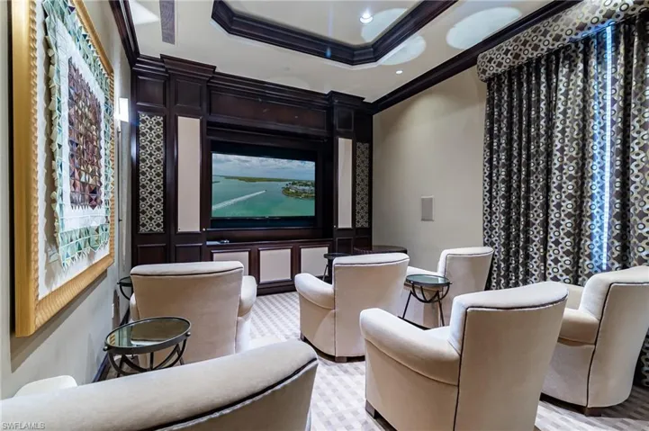 Cinema room featuring ornamental molding and a tray ceiling