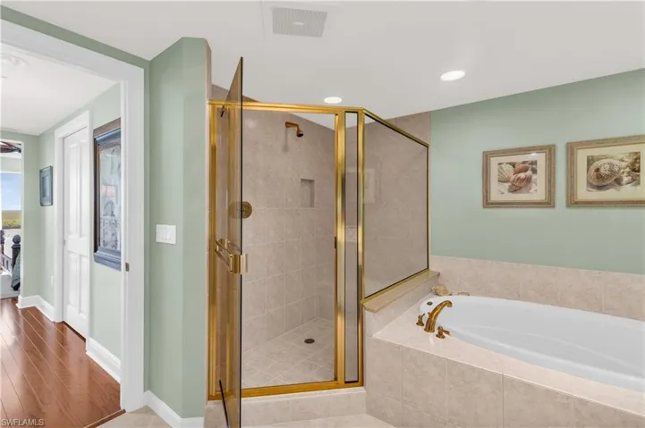 Bathroom featuring hardwood / wood-style flooring and separate shower and tub