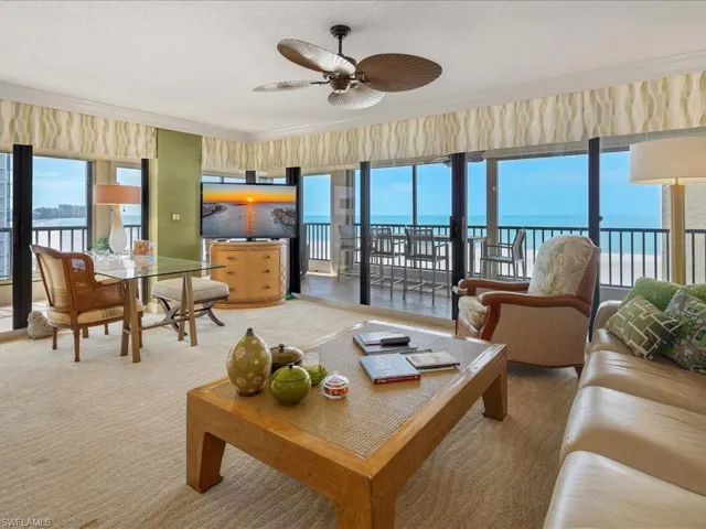 Carpeted living area featuring healthy amount of natural light, ceiling fan, and ornamental molding