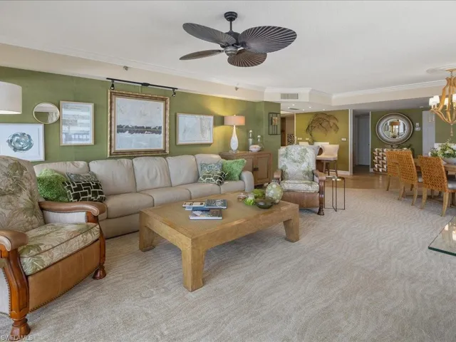 Living area featuring ornamental molding and a chandelier