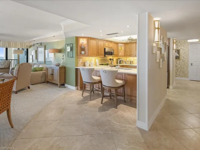 Kitchen with a breakfast bar area, open floor plan, tasteful backsplash, brown cabinets, and a peninsula