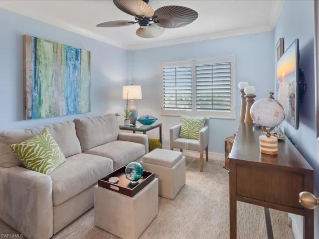 Living room featuring crown molding, a textured ceiling, and ceiling fan