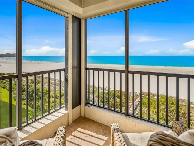 Sunroom / solarium featuring view of water and beach and tile patterned floors