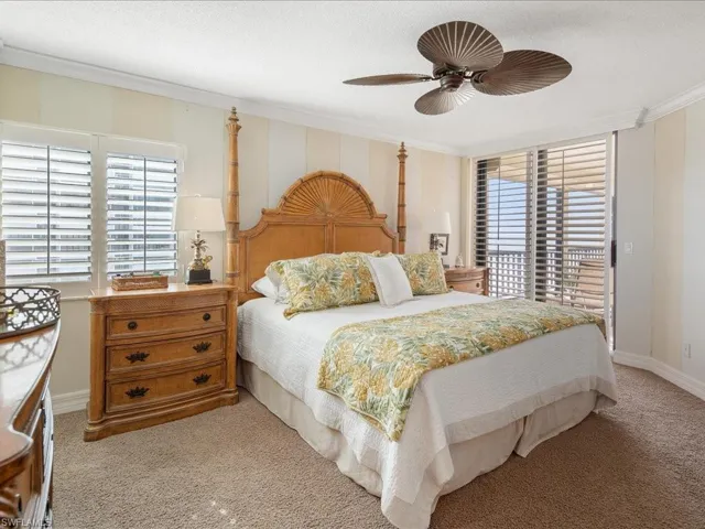Bedroom featuring light colored carpet, ceiling fan, and ornamental molding