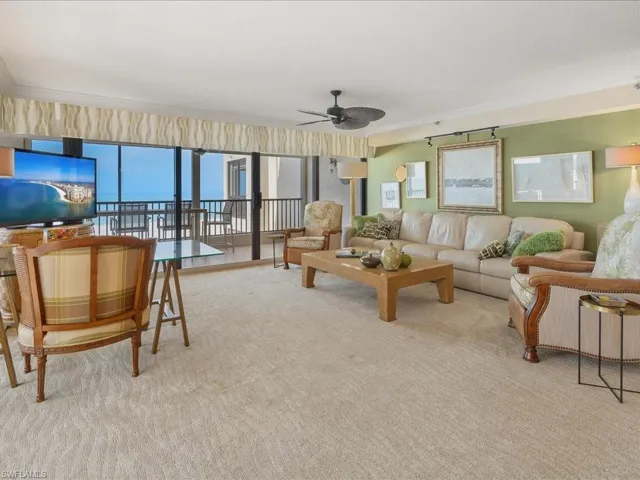 Living room featuring crown molding, ceiling fan, and light carpet