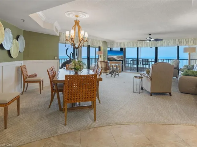 Dining area with plenty of natural light, wainscoting, light carpet, ornamental molding, and a ceiling fan