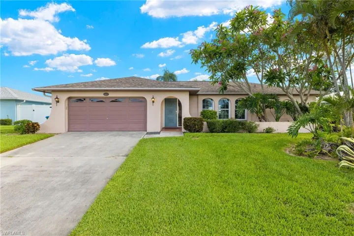 Single story home with a garage and a front yard