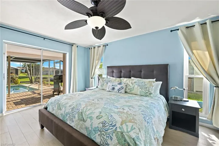 Bedroom with ceiling fan, access to exterior, and light wood-style floors